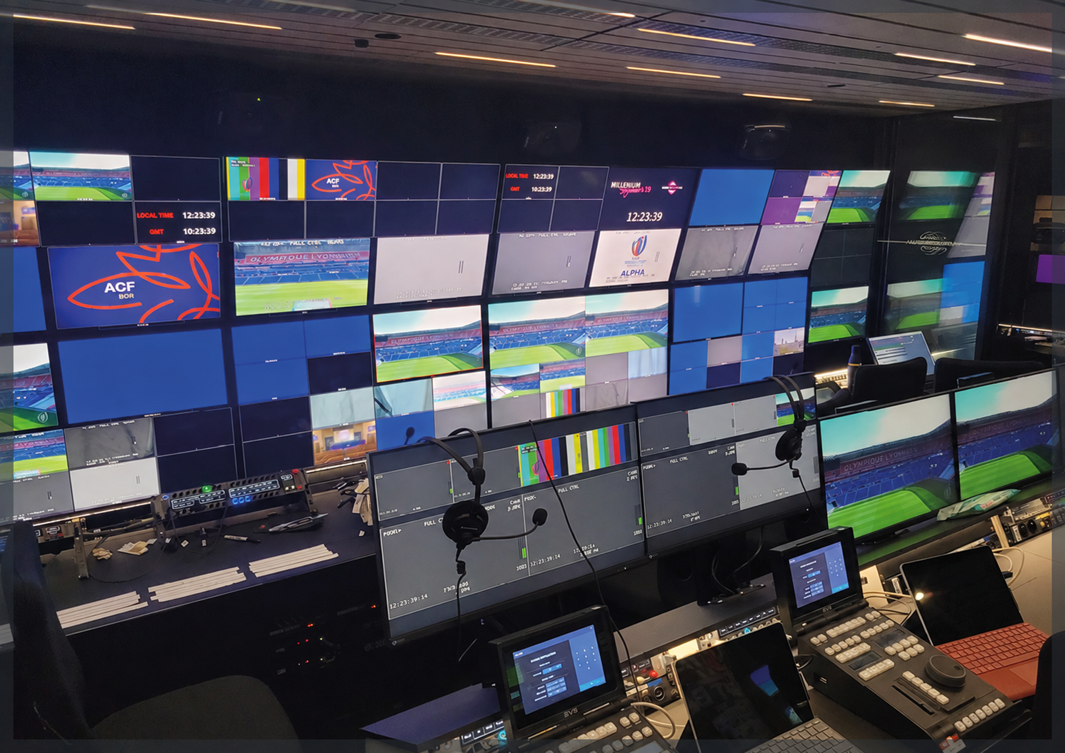 Postes de travail, intercoms et mur de moniteurs d’une régie de production sportive